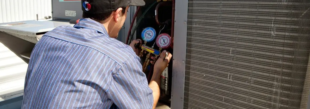 HVAC technician servicing a condenser unit in Hoboken